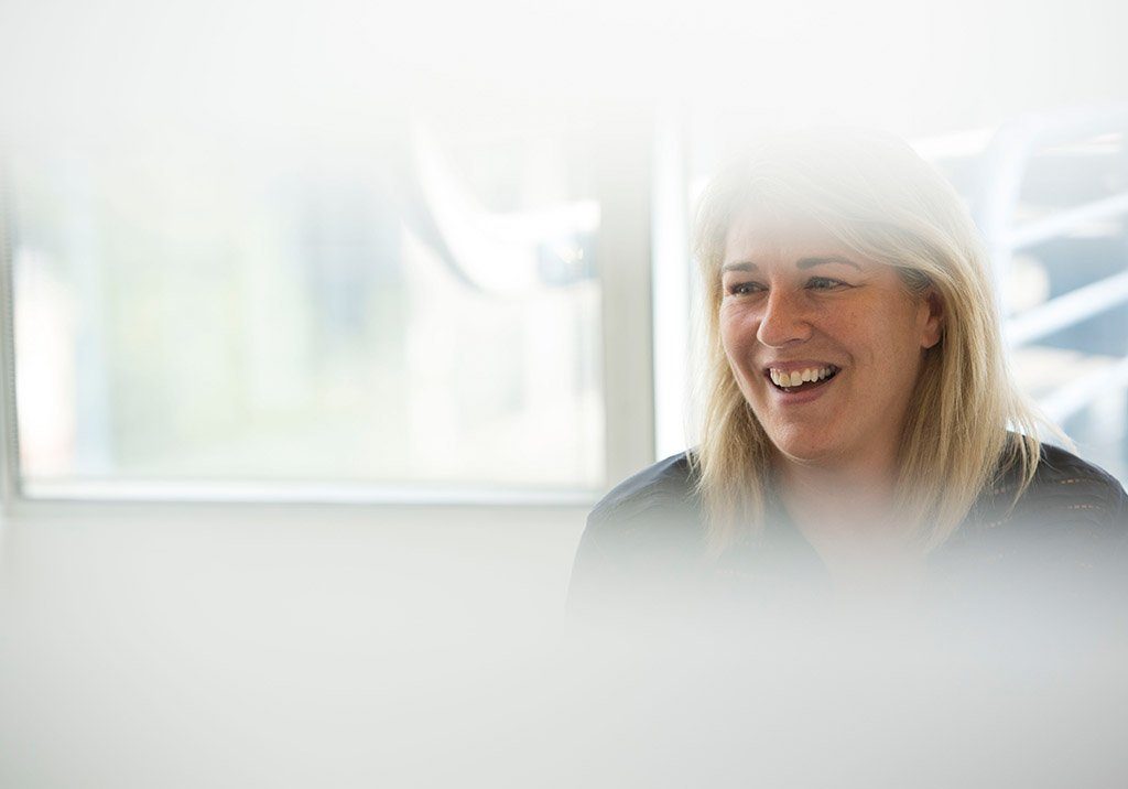 Recordsure founder Joanne Smith smiling in a bright office, with the left side faded to white