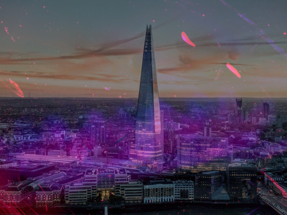 The Shard towering over the London skyline at dusk, overlaid with purple and red light particles