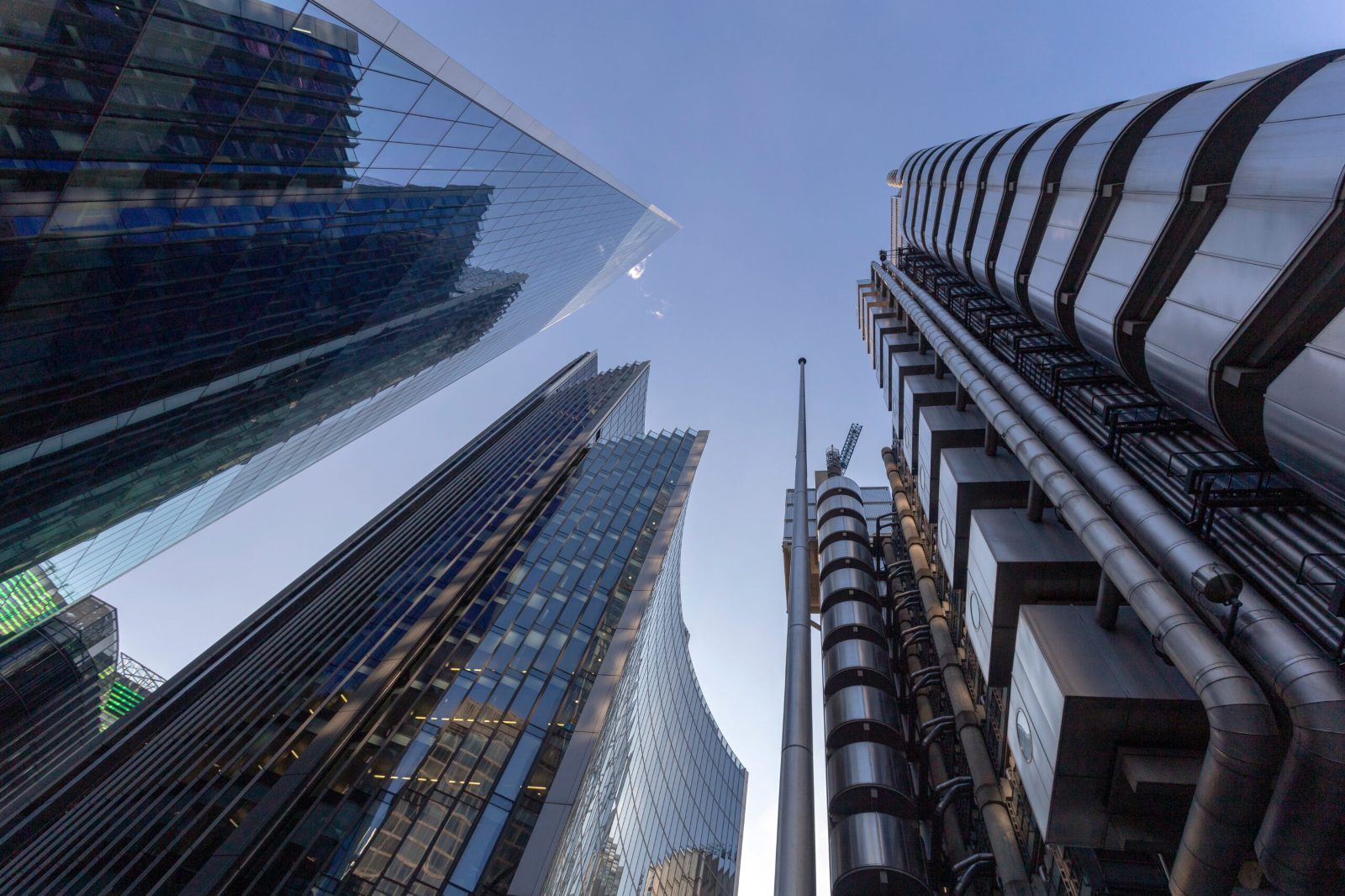 Looking up between glass skyscrapers and the steel-clad Lloyd's building in the City of London