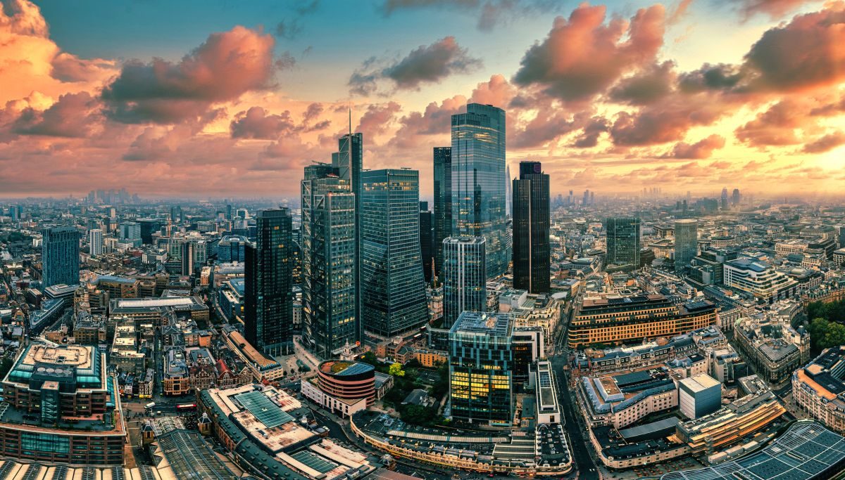 Aerial view of the City of London skyscrapers at sunset under pink and orange clouds