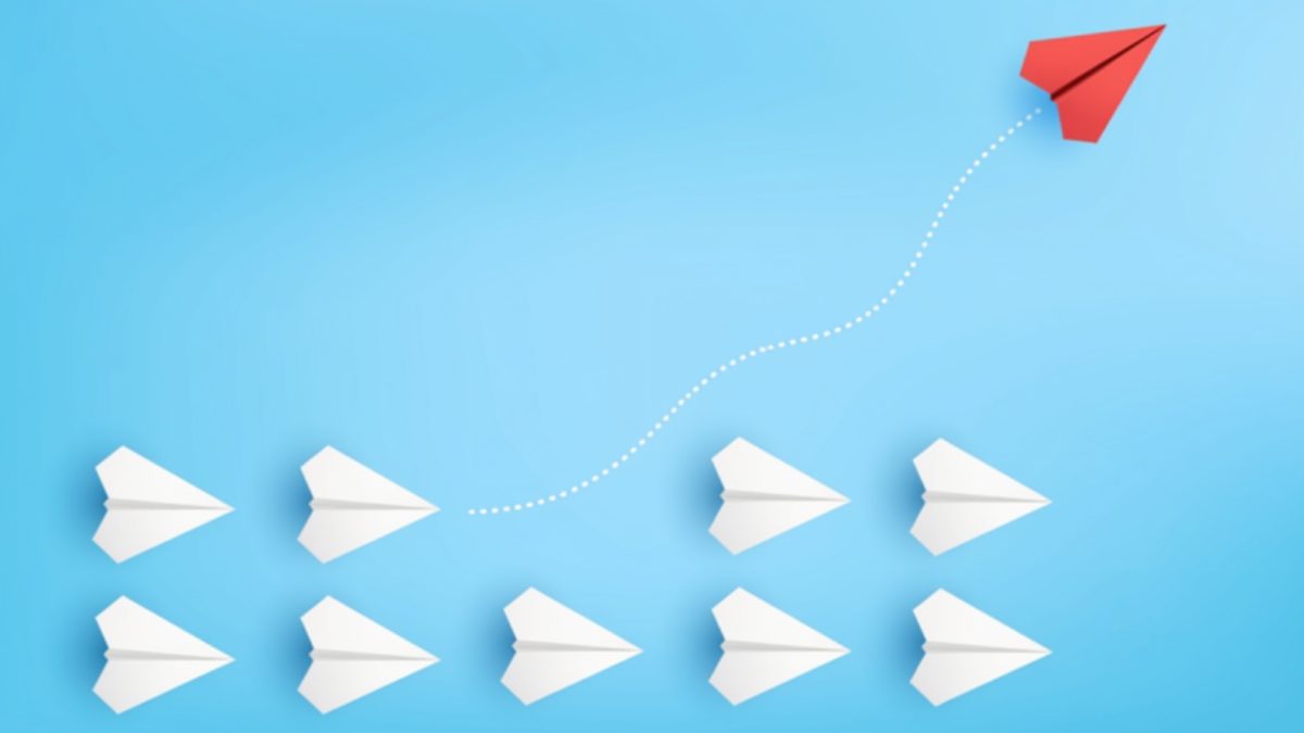 Two rows of white paper planes with a red plane rising away along a dotted line, on a light blue background