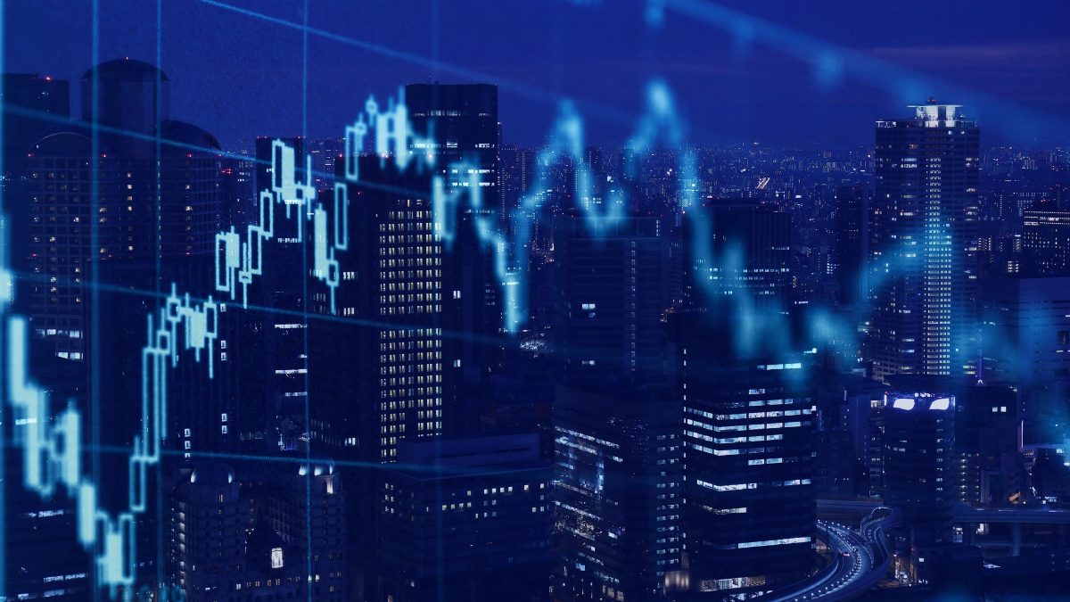Night-time city skyline overlaid with a blue candlestick chart and line graph