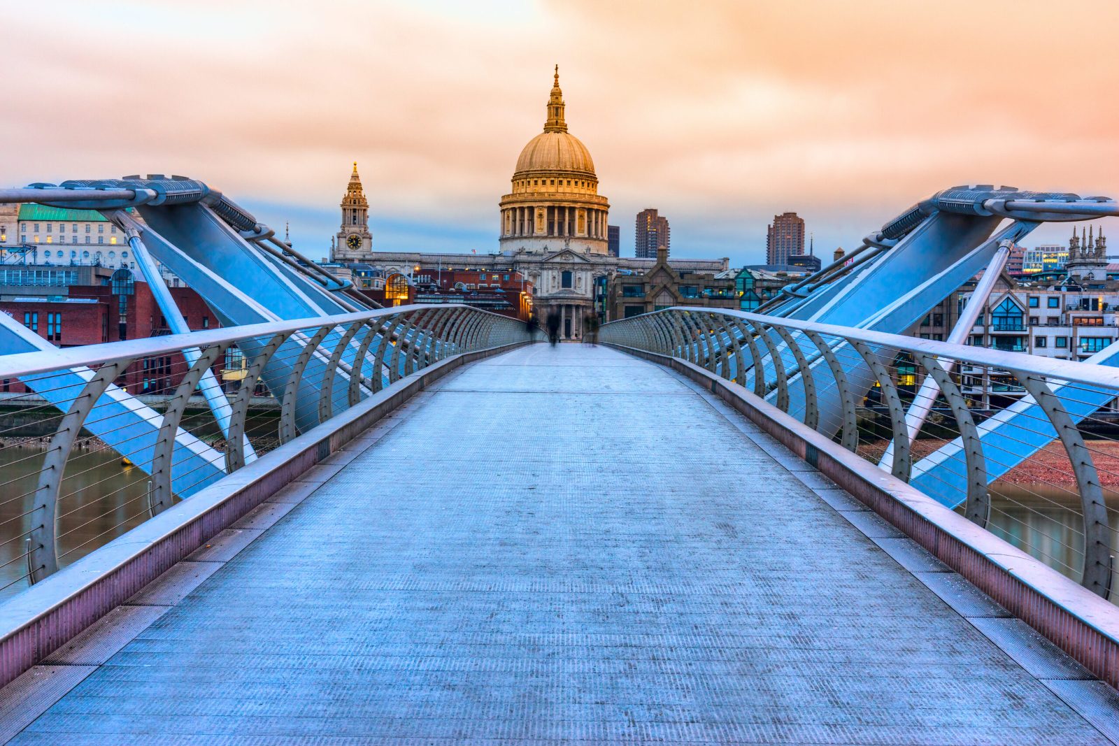 Millennium Bridge leading across the Thames towards the dome of St Paul's Cathedral at dusk