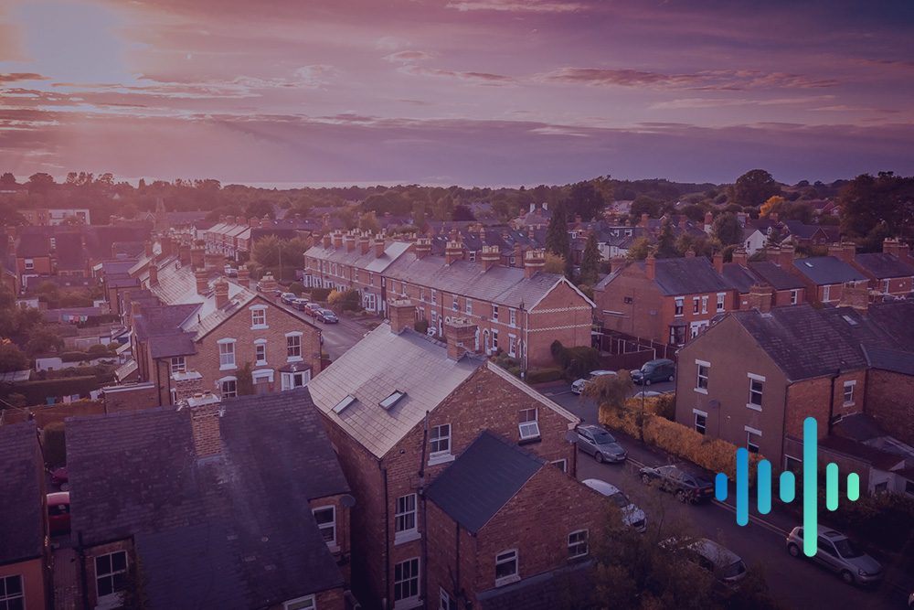 Aerial view of streets of terraced houses and parked cars at dusk under a purple-tinted sky