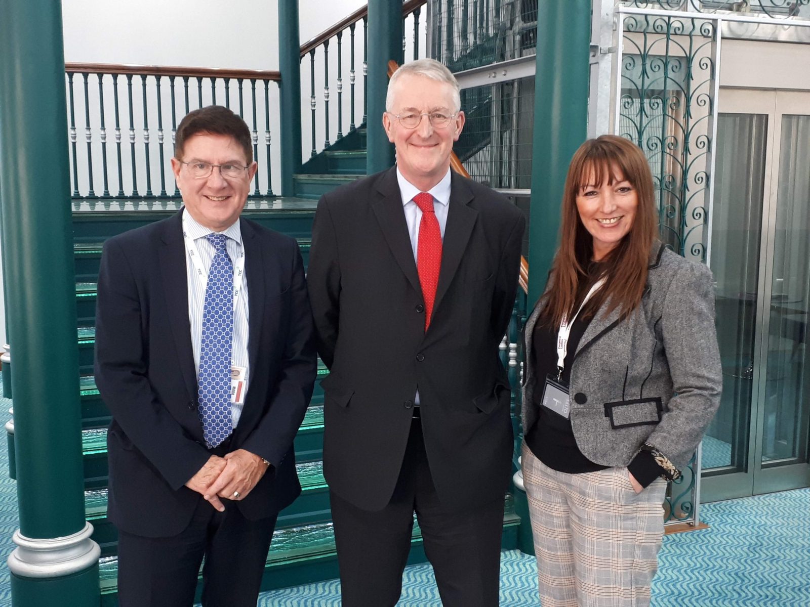 Hilary Benn MP, centre, with two Recordsure hosts on a staircase during his visit to the Leeds office