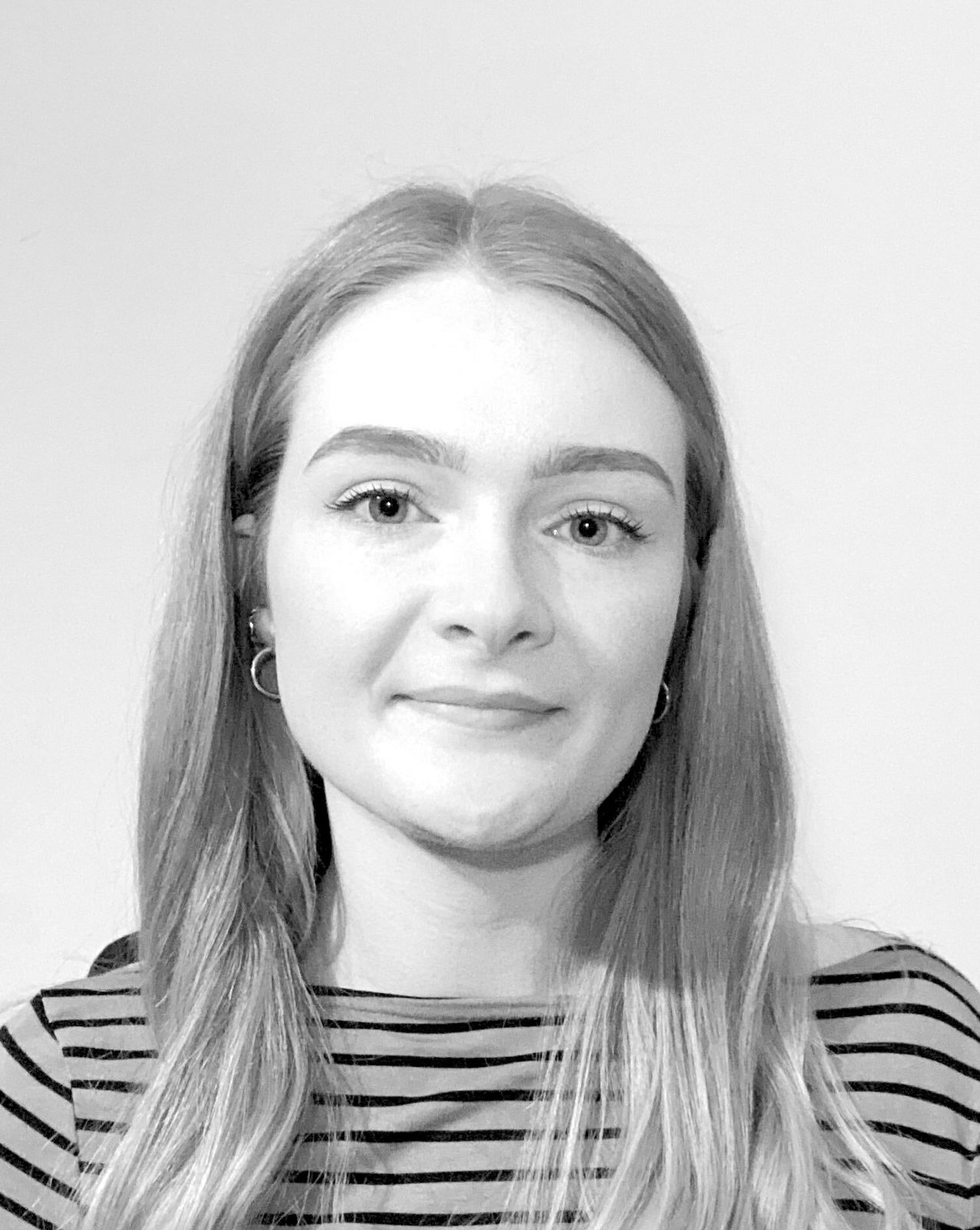 Black-and-white portrait of Maisie Mattison, AI Training Lead, in a striped top